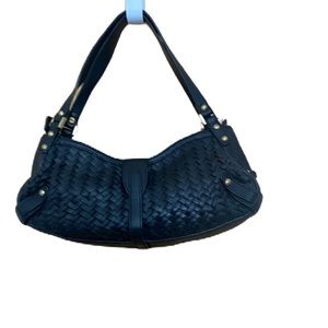 Black leather Cole Haan purse with weave pattern detail.
